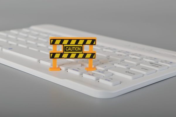 Laptop keyboard and caution sign.system hacked. Virus, cyber attack and malware concept